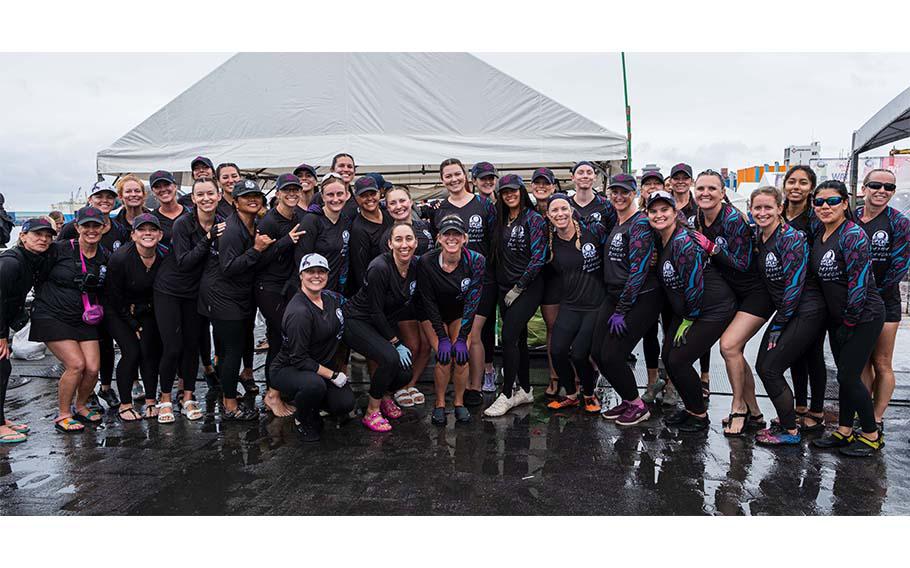 A dragon boat team smiling for a group photo.